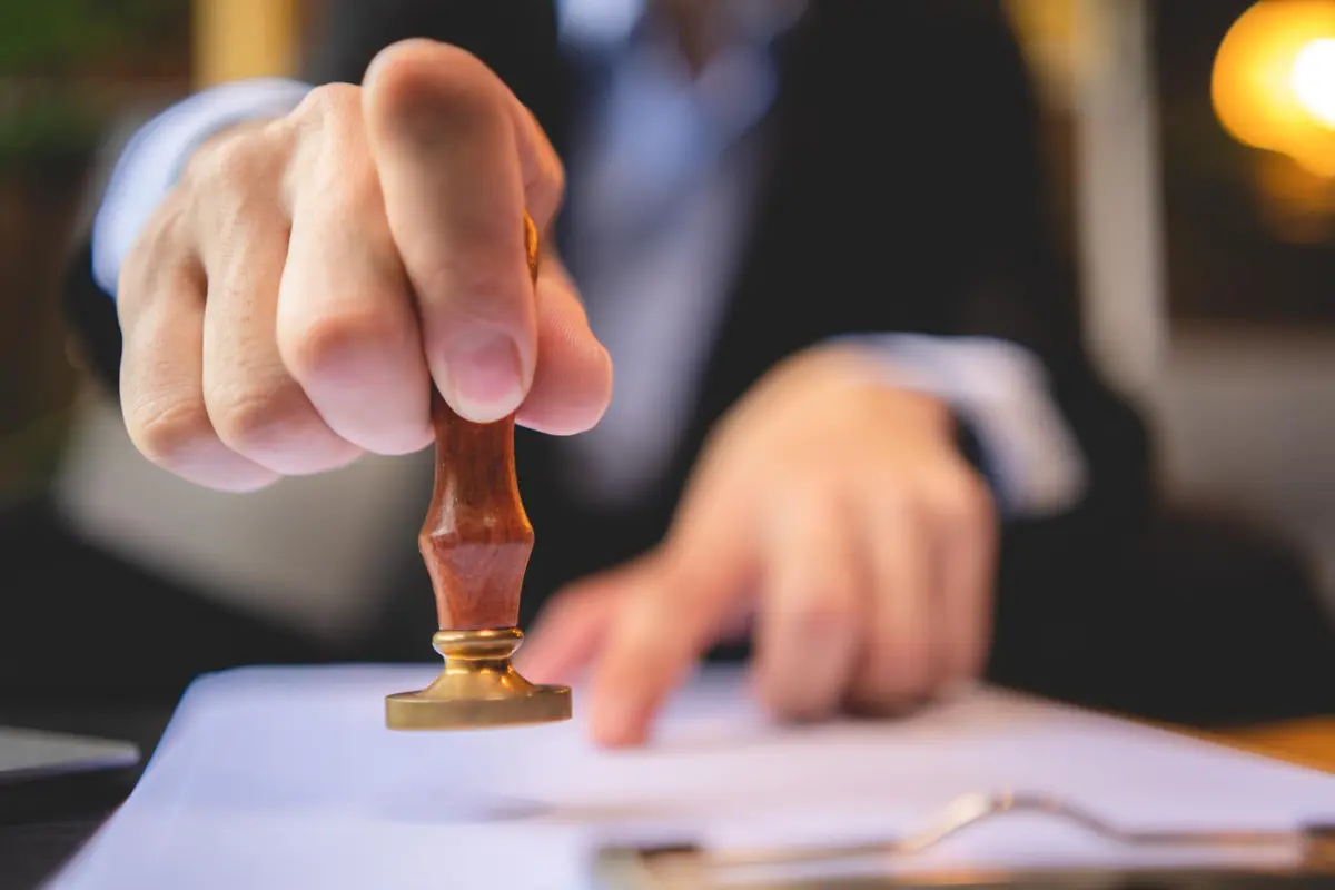 Man in pak met bronzen wasstempel voor apostille document