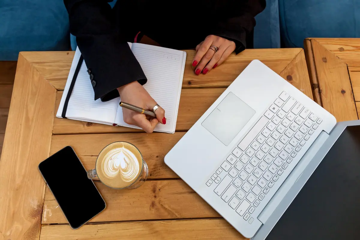 Bovenaanzicht schrijven met witte laptop en koffie voor copywriting