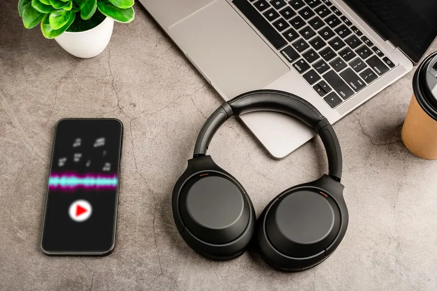 Koptelefoon en audiogolfvorm op laptop voor transcriptie service