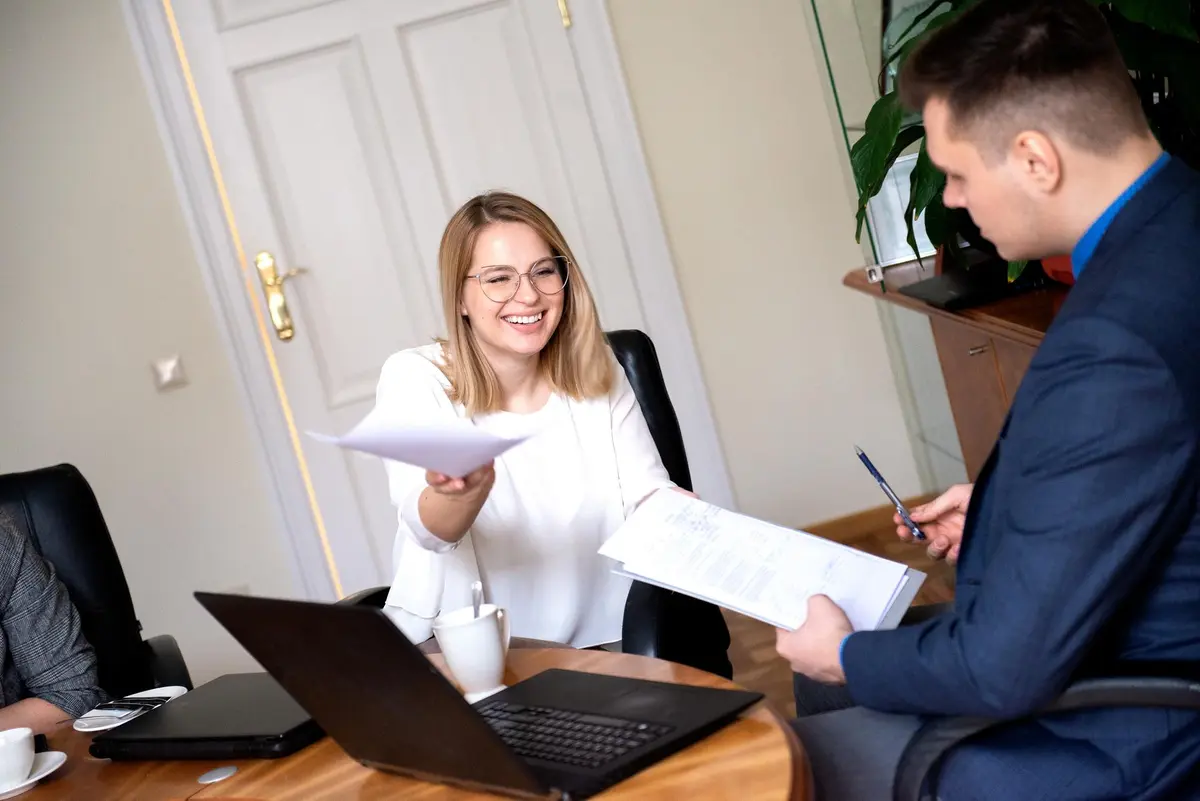 Vrouw en man wisselen documenten uit op kantoor voor VOG screening